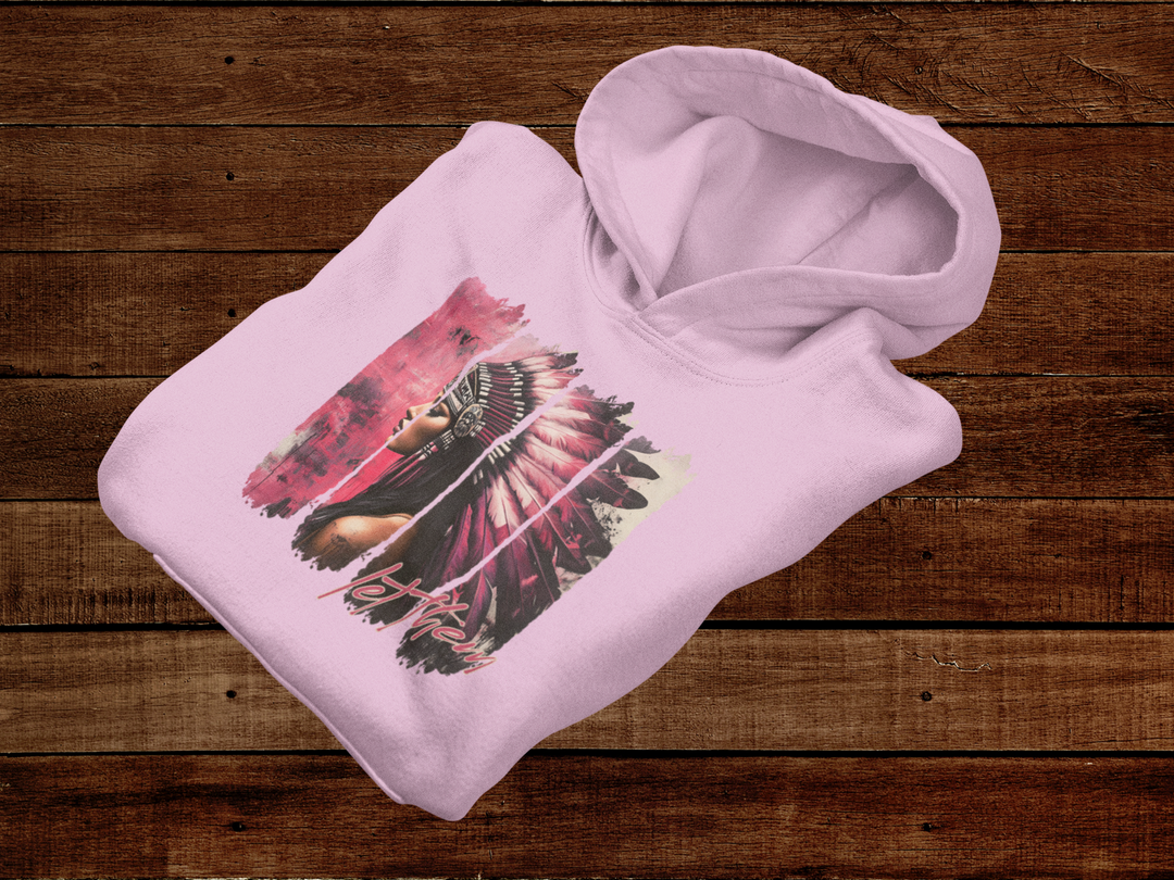 Pink hoodie with a colorful graphic design on a wooden surface