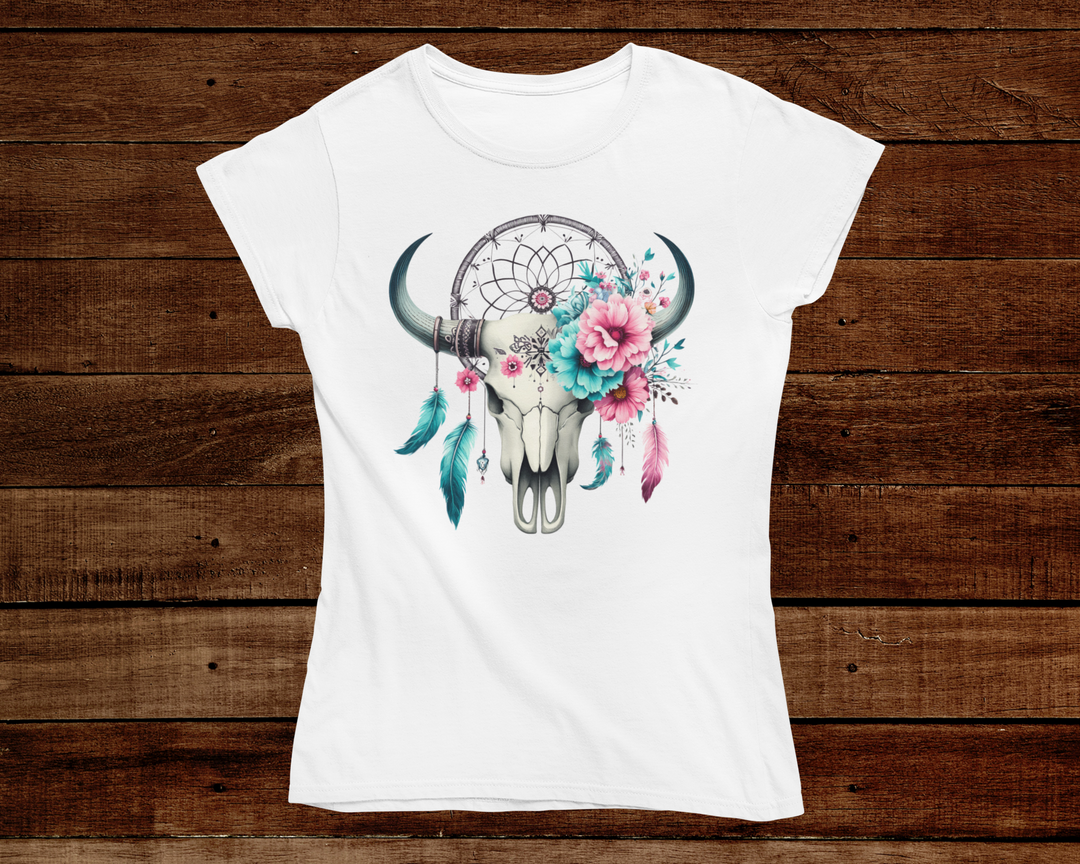 White t-shirt with a bull skull, dreamcatcher, and flowers design on a wooden background
