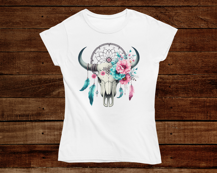 White t-shirt with a bull skull, dreamcatcher, and flowers design on a wooden background